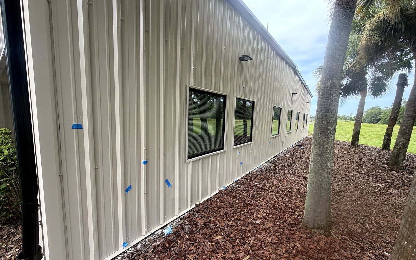 Commercial metal building exterior painting at MCO Airport property, Orlando